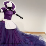 A sculpture of a woman made of fiberglass wearing a purple dress with fluffy purple tulle.