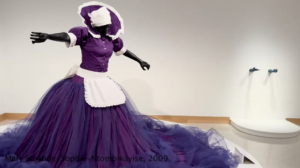 A sculpture of a woman made of fiberglass wearing a purple dress with fluffy purple tulle.