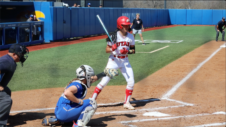 A catcher for the University of Kansas sits behind a batter for the University of Utah