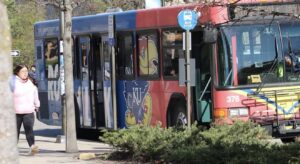 KU bus on the road stopping at a bus stop