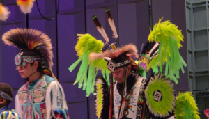 two people in indigenous regalia