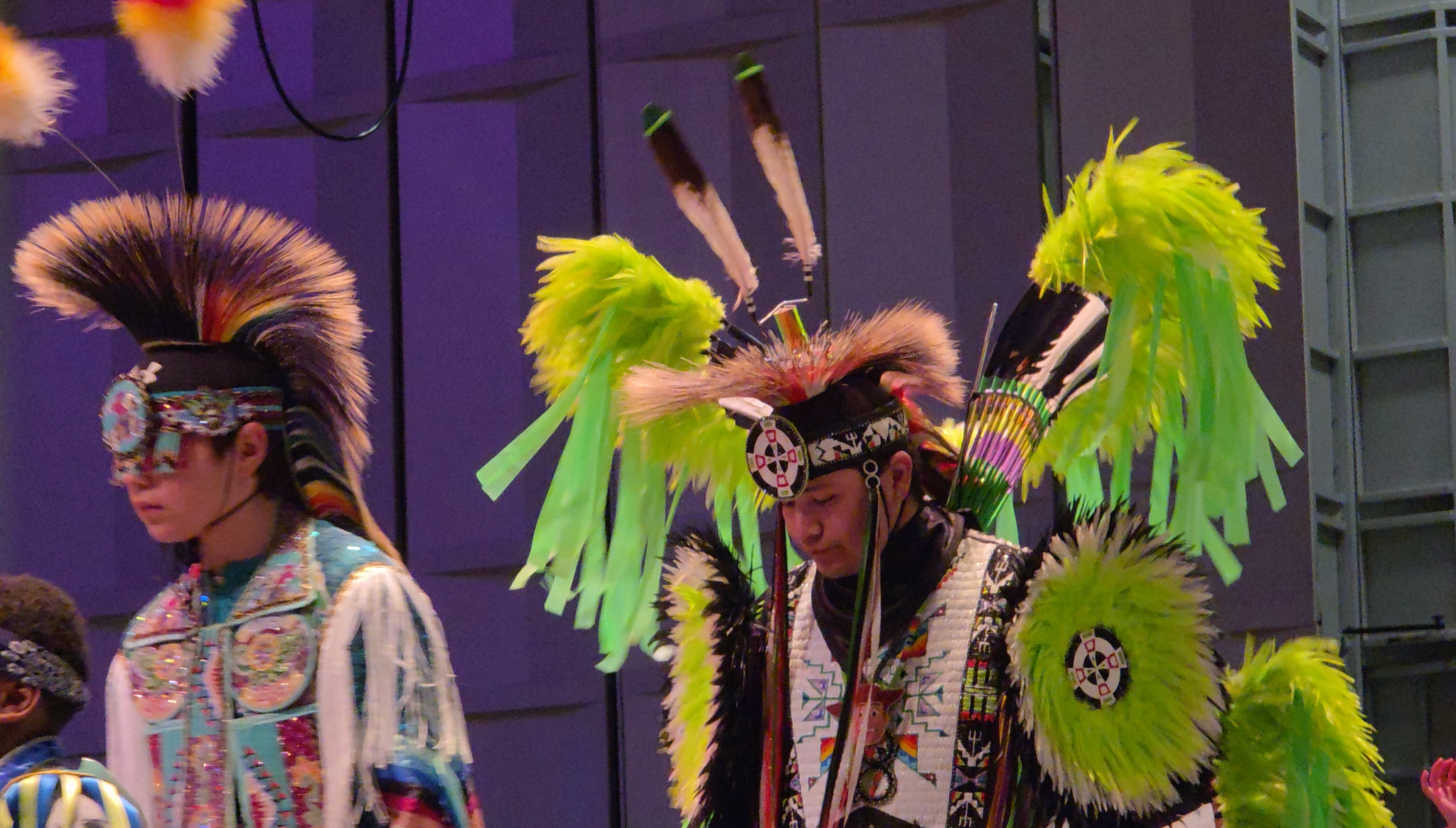 two people in indigenous regalia