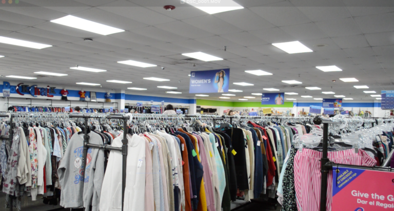 Racks of clothing sit on hangers inside a thrift store